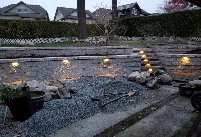 stone retaining wall and staircase with garden lights
