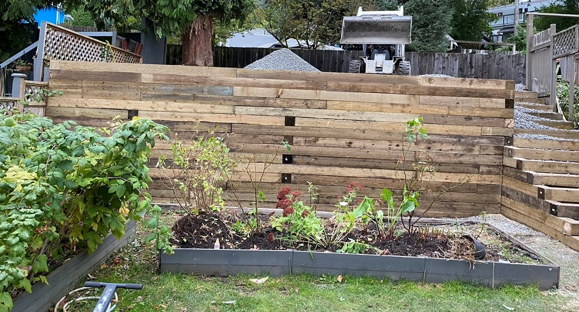 wooden retaining wall surrounding green garden